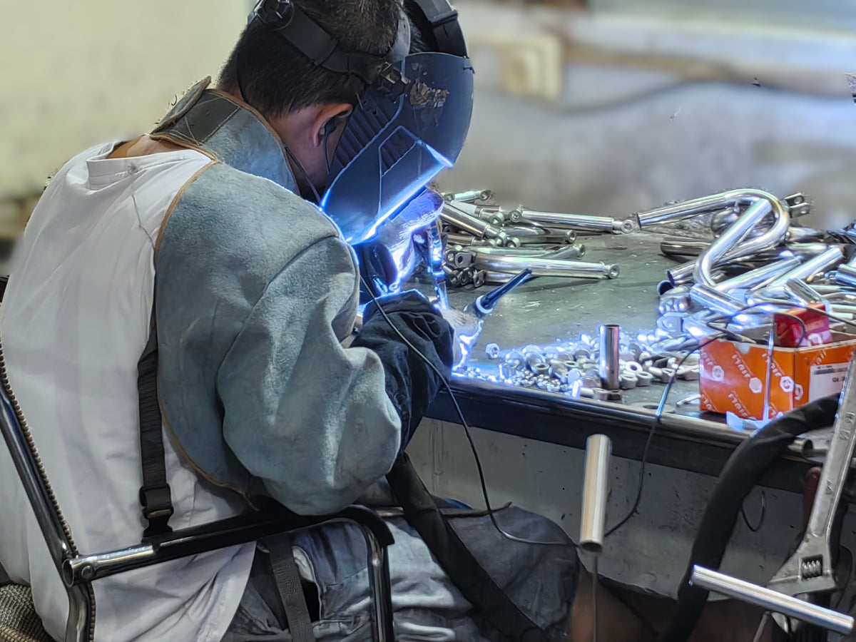 A craftsperson welding a doll skeleton in the Pygmalion Doll manufacturing workshop